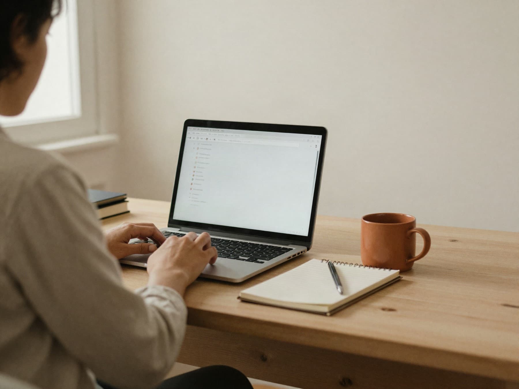 Someone working at a laptop in a quiet, warm room